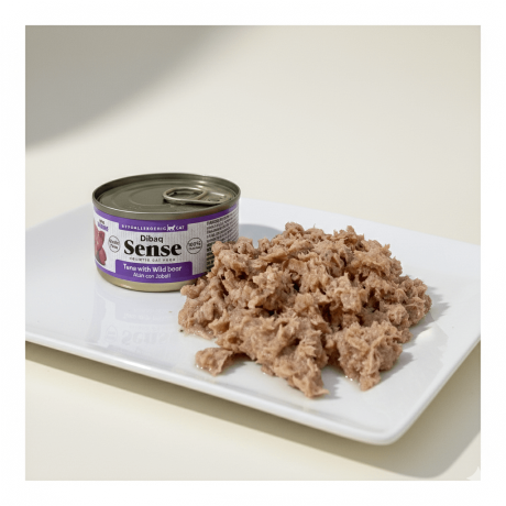 Lata de comida húmeda Dibaq Sense de atún con jabalí abierta junto a una ración de paté servida en plato blanco