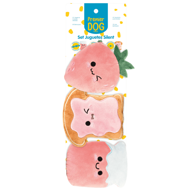 Conjunto de 3 juguetes de peluche para perros de Premier DOG con temática de desayuno, incluyendo una fresa roja, una tostada de pana con huevo frito y un dispensador circular rosa, presentados en su embalaje de cartón amarillo.