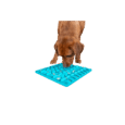 Vista de un perro lamiendo el mantel Trixie Lick'n'Snack azul. Se puede ver el patrón de rejilla lleno de snacks húmedos o paté, y el perro usando su lengua para extraer la comida.