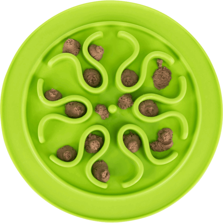 Vista cenital del comedero slow feed redondo Trixie de 24cm, color verde limón, con porciones de alimento húmedo esparcidas en el patrón central de ondas que simulan una flor o estrella.