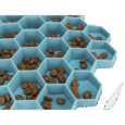 Vista de cerca del comedero Trixie Colmena azul de 30cm, con croquetas de pienso dispersas individualmente en las celdas hexagonales. Muestra cómo las celdas separan el alimento.