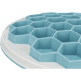 Primer plano del comedero Slow Feeding Trixie con diseño de colmena hexagonal (azul sobre blanco). Resalta la textura de nido de abeja ideal para comida húmeda y patés.