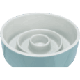 Vista en ángulo del comedero Slow Feeding de cerámica Trixie de 17cm con diseño bicolor: exterior azul claro e interior de anillos concéntricos blancos. El ángulo muestra la profundidad de los obstáculos y el perfil bajo del comedero.