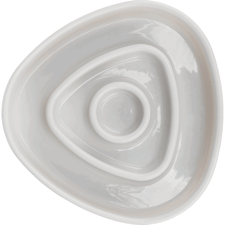 Vista superior del comedero Trixie Slow Feeding (15cm), de color blanco, contrastando con el fondo negro. El diseño triangular concéntrico ralentiza la alimentación de perros y gatos.