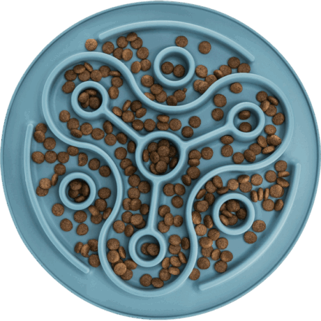 Vista cenital del mantel Slow Feeding Trixie azul de 28cm lleno de croquetas de pienso. El pienso está distribuido a lo largo del laberinto curvo y en los orificios.