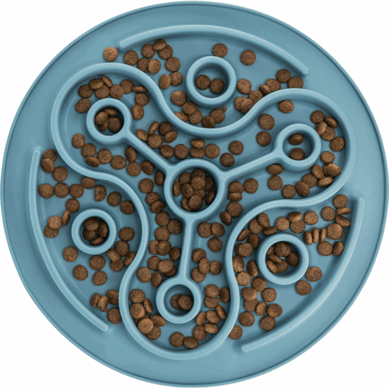Vista cenital del mantel Slow Feeding Trixie azul de 28cm lleno de croquetas de pienso. El pienso está distribuido a lo largo del laberinto curvo y en los orificios.