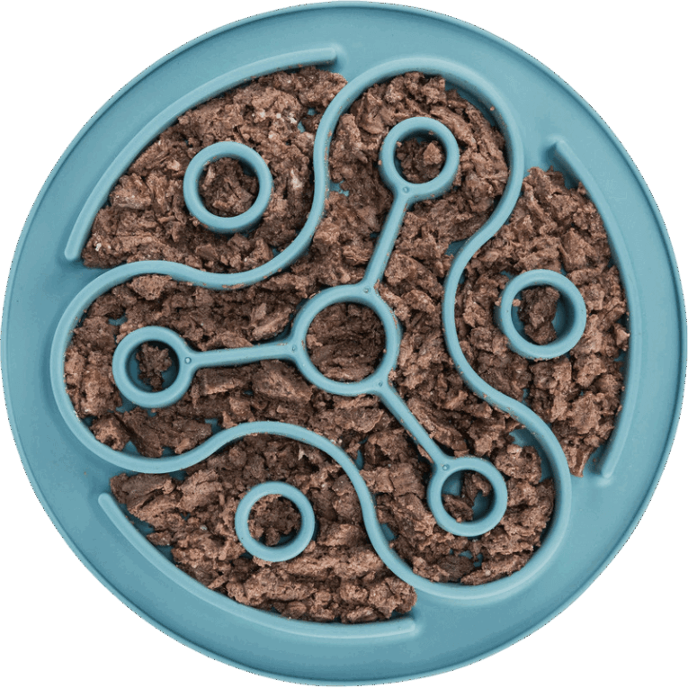 Vista cenital del mantel Slow Feeding Trixie azul de 28cm con el laberinto lleno de comida húmeda o paté de color marrón. Muestra la superficie ideal para esparcir y lamer.