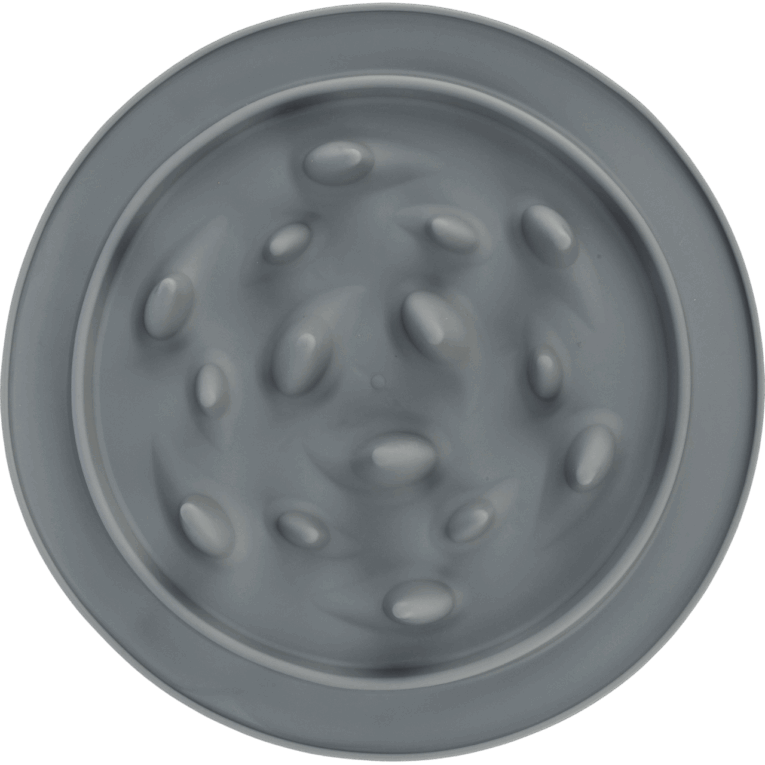 Vista cenital del comedero Slow Feed Trixie de 24cm en color gris claro. La superficie está cubierta de obstáculos en forma de óvalos o guijarros distribuidos irregularmente para ralentizar la comida.