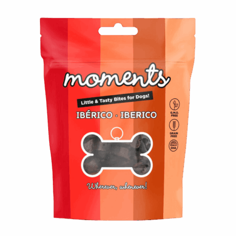 Bolsa individual de 60 gramos de snacks Moments sabor Cerdo Ibérico, con la silueta de un hueso, ideales para llevar en paseos y adiestramiento.