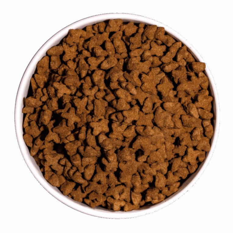 Croquetas de pienso Ownat Just Grain Free Sterilized de pollo, con forma de hueso/estrella, servidas en un cuenco blanco, para gatos esterilizados.